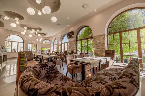 皮耶什佳尼City Hotel的餐厅设有桌椅和窗户。