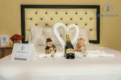 ChepénHotel Jose Ignacio Chepen的一张带两瓶香槟和天鹅毛巾的床