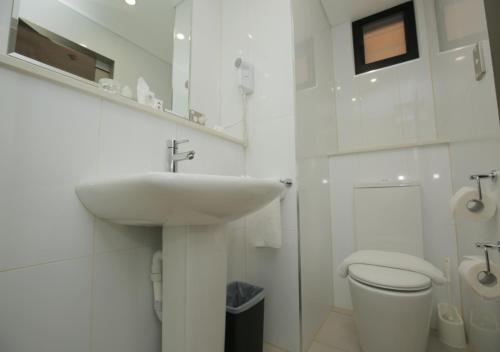 莫尔兹比港埃拉海滩酒店的白色的浴室设有水槽和卫生间。