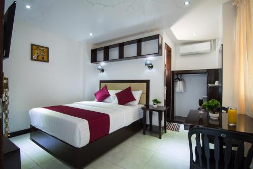 卡塔曼Diamond Hotel And Resto的配有一张床和一张书桌的酒店客房
