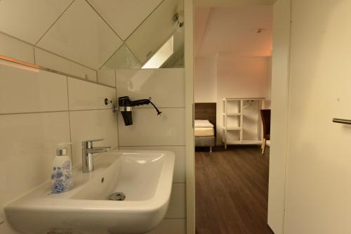 新勃兰登堡Hotel Weinert的带白色水槽的卧室