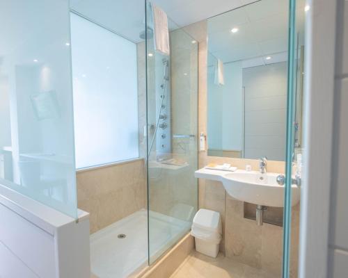 萨卡罗萨加罗健康水疗酒店的带淋浴、盥洗盆和卫生间的浴室