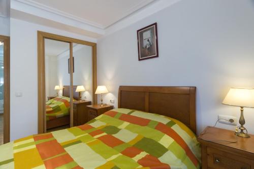 萨莫拉Merlú Apartamento con garaje的一间卧室配有一张色彩缤纷的床和镜子