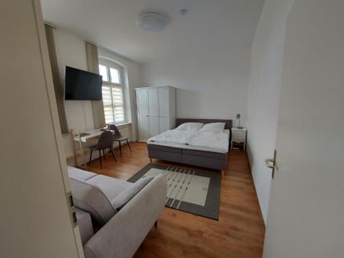 施韦特Ferienwohnung Zum Rapunzelturm的一间卧室配有一张床、一张沙发和一张桌子