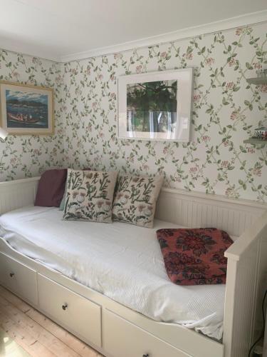 卢恩斯基尔Lyckorna 62:1的一张位于带花卉壁纸的房间的床铺