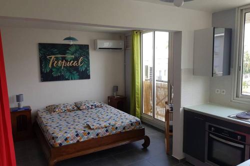 皮特尔角城Le Repère tropical à la Marina的一间带床的卧室,位于带窗户的房间内
