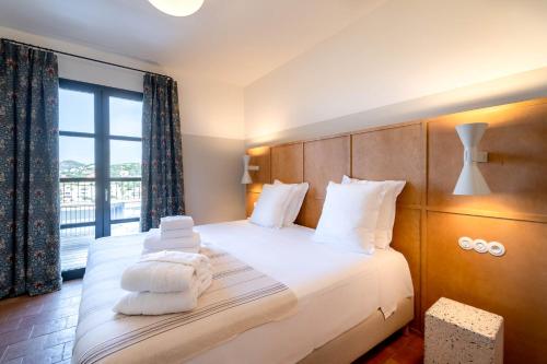 利勒鲁斯Hôtel Restaurant Villa Joséphine的一间卧室配有一张带白色毛巾的床