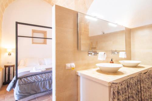 桑坦伊Finca Agroturismo Es Pujol的一间带两个盥洗盆的浴室和一张位于客房内的床。