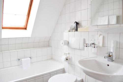 莱因斯韦勒山庄酒店及餐厅的白色的浴室设有水槽和卫生间。