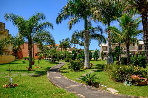 弗洛里亚诺波利斯Villa Oliva Residence的一条 ⁇ 的路径穿过一个种有棕榈树的公园