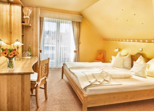 魏森湖Kraners Alpenhof BIO Bed and Breakfast Pension的一间卧室配有一张大床、一张桌子和一张桌子