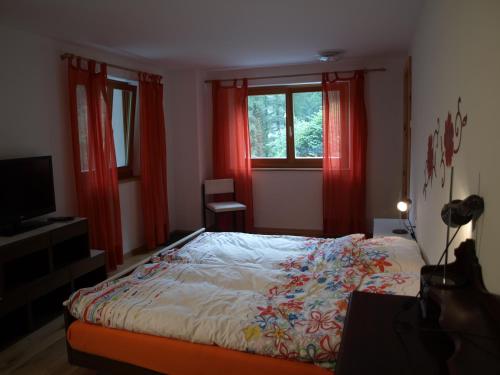 博斯克古林卡萨莫尼住宿加早餐旅馆的一间卧室配有床、红色窗帘和电视