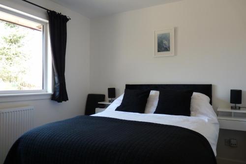 斯佩河畔格兰敦Tanleys Guesthouse的卧室设有黑白床和窗户。