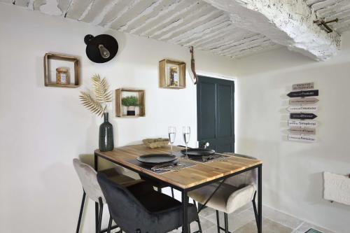 卢马罕La Maison de Lourmarin的一间带木桌和椅子的用餐室