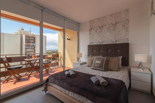 奎特里拉SUITE ON 7TH VILAMOURA THE BEST VIEW IN TOWN - 1Br的一间带大床的卧室和一个阳台