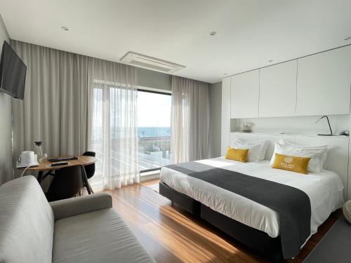 蓬塔德尔加达Praia de Santos, Exclusive Villa, Açores的一间卧室配有一张大床、一张书桌和一个窗户。