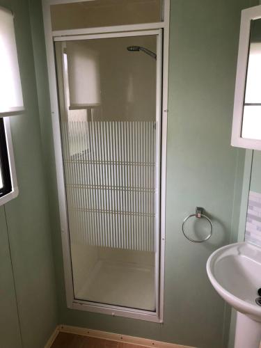 伯克顿Norfolk Poppy Caravan - Sleeps 4 - WiFi and Sky TV Included的一个带水槽的玻璃淋浴间