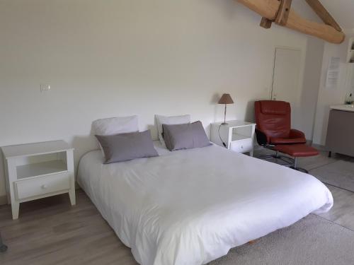 RouffignacStudio grand confort的卧室配有一张白色大床和红色椅子