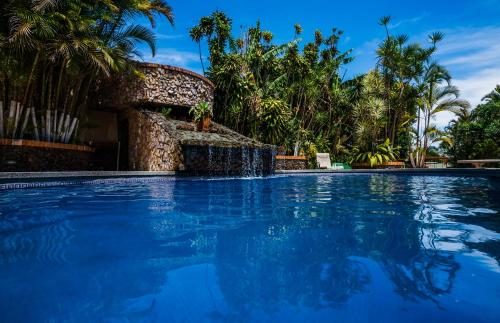 埃雷迪亚西贝莱斯度假酒店的度假村内带瀑布的游泳池