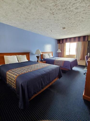Central CityVICTORIAN INN的酒店客房设有两张床和蓝色的墙壁。