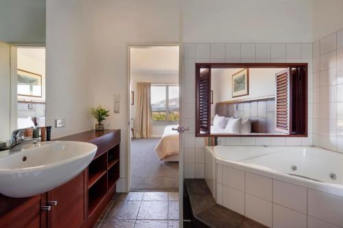 温德维索Fable Terrace Downs Resort by MGallery的带浴缸、水槽和镜子的浴室