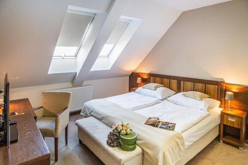 兹沃伦学术酒店的卧室配有带天窗的大型白色床。