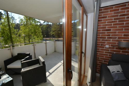 斯蒂格纳Apartment Premium Wood Baltic Park - 58m2, 3 pokoje的阳台设有滑动玻璃门和砖墙