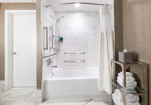 华盛顿The Churchill Hotel Near Embassy Row的白色的浴室设有浴缸和淋浴。