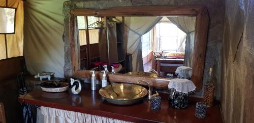 AitongMara Siria Tented Camp & Cottages的浴室的柜台设有水槽和镜子