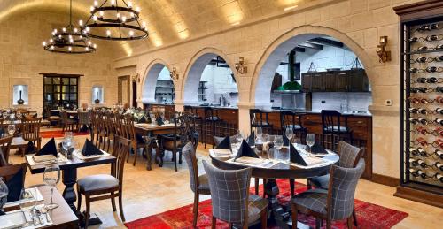 于尔居普Seraphim Cave Suites & SPA的一间带桌椅的餐厅和一间酒吧