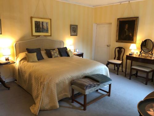 格兰瑟姆Marston Hall的一间卧室配有一张大床和一张桌子及椅子