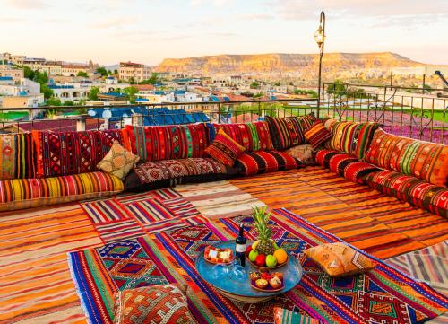 格雷梅Lord of Cappadocia Hotel的阳台上的沙发,配有带水果的桌子