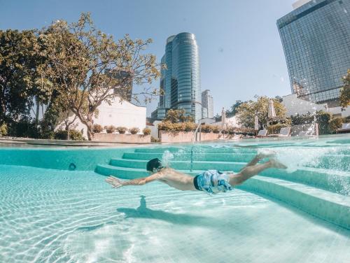 曼谷曼谷愛侶灣君悦酒店的一个人在游泳池游泳