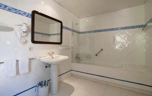 帕格拉巴伊亚酒店的一间带水槽、浴缸和镜子的浴室