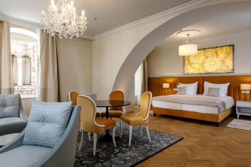 斯普利特Heritage hotel Santa Lucia的卧室配有一张床和一张桌子及椅子