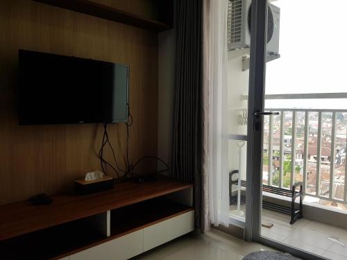 日惹Apartemen Taman Melati Sinduadi 60的客房设有平面电视和窗户。
