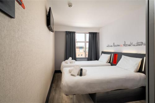 牛津easyHotel Oxford的酒店客房设有两张床和窗户。