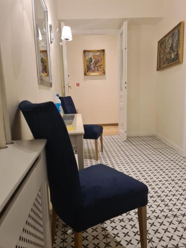 克拉科夫琥珀旅馆的一间设有蓝色椅子和一张书桌的等候室