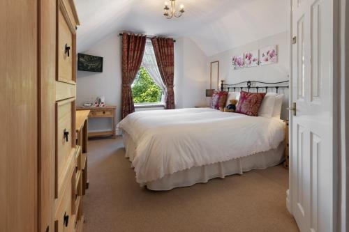 鲍内斯温德米尔比奇伍德酒店的卧室设有一张白色大床和一扇窗户。