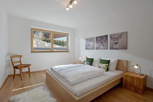 埃尔毛Appartement Rehkitz的白色卧室配有床和椅子