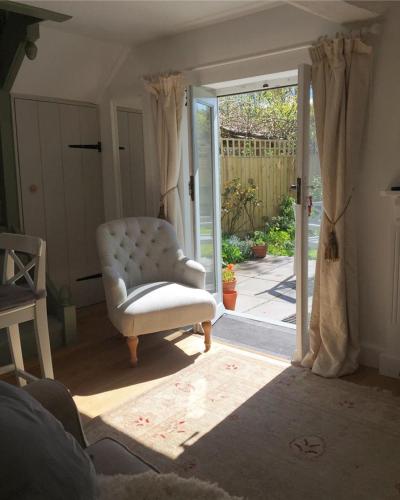 查格福德Wrenscott的客厅配有白色椅子和滑动玻璃门