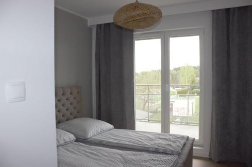 维尔卡瑟Apartamenty na skarpie - Niegocińska 2,的一间卧室设有一张床和一个大窗户