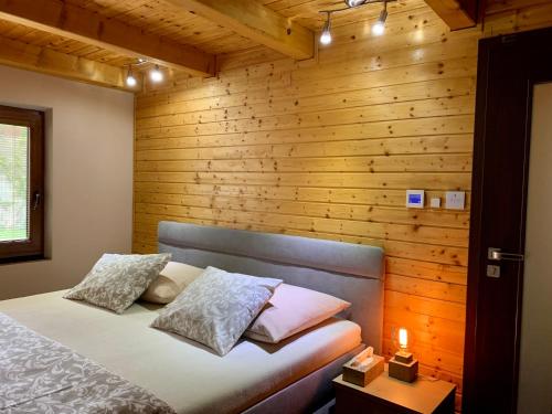 斯科林特普利采Grand Spa Holiday Home的一间卧室设有一张床和木墙