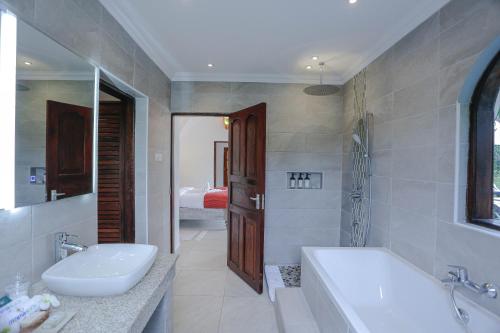 迪亚尼海滩Mzima Beach Residences - Diani Beach的带浴缸、水槽和浴缸的浴室
