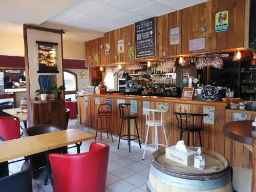 Sainte-Marie-de-CuinesLe Grand Chatelard HÔTEL BAR RESTAURANT的餐厅设有酒吧,配有桌椅