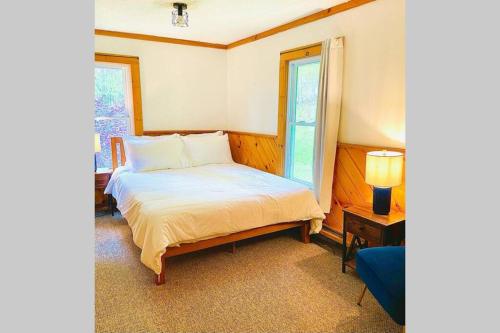 Livingston ManorCozy and Charming Cottage with Jacuzzi and Fire Pit!的一间卧室设有一张床和一个窗口