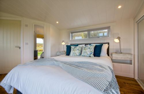 RingfordThe Pond Lodges Barstobrick的卧室配有带蓝色枕头的大型白色床