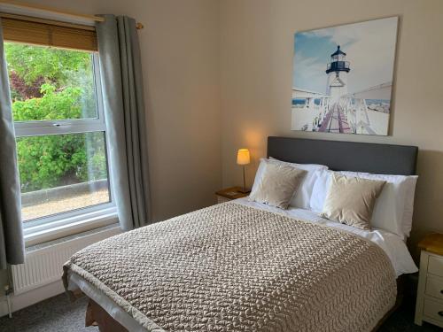 尚克林栗子酒店的一间卧室设有一张床,窗户设有灯塔