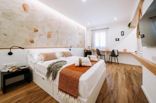 休达德亚Murada hotel的一间卧室设有一张大床和石墙