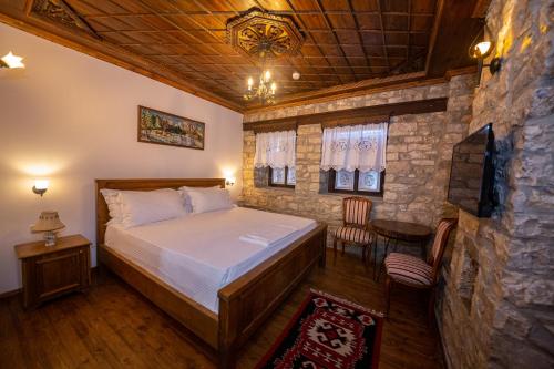 培拉特Berati Castle Hotel的一间卧室设有一张床和石墙